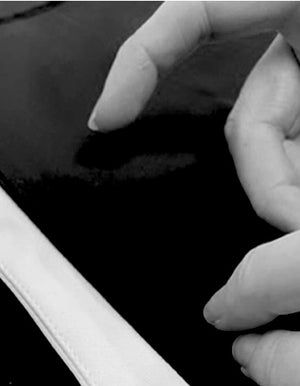 Hands delicately resting on fabric, making a product