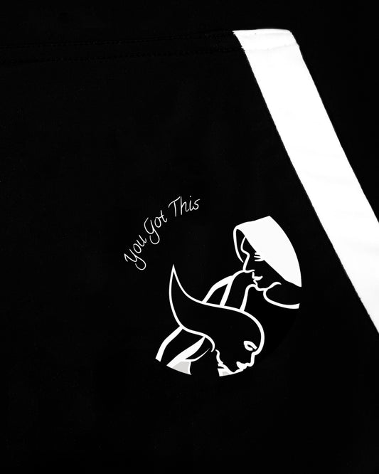 Close up of GoofyPRO Cayton Core Hoodie in black. With water based graphic design of GoofyPRO man supporting GoofyPRO woman in a race, on front pocket.