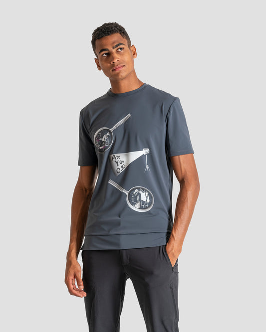 GoofyPRO Cayton Core Performance Tshirt in Titanium with short sleeves. A graphic of two magnifying glasses with a spotlight asking Are You O.K? worn by model