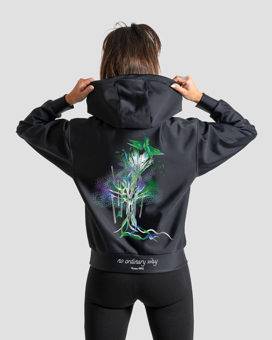 GoofyPRO Cayton XTR Hoodie in black. A graphic of a colourful bird flying out of a colourful tree with ribbons in Green seasonal colours. White embroidered 'no ordinary way' on waistband.