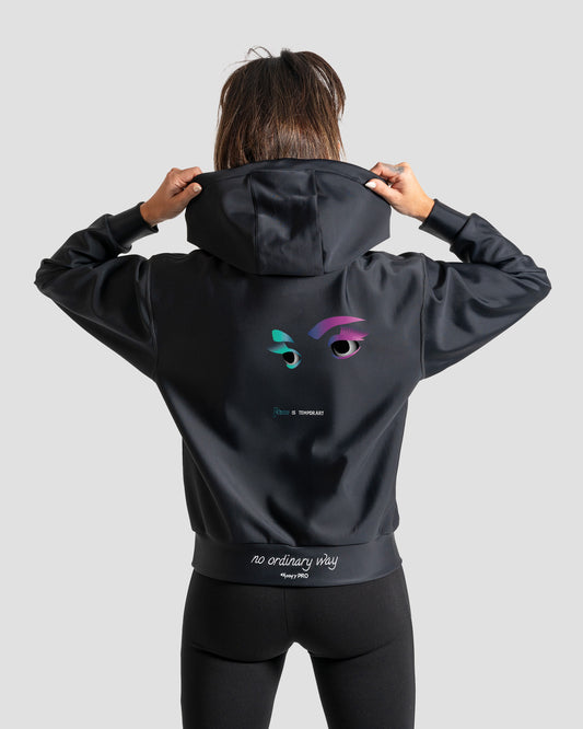 GoofyPRO Cayton XTR hoodie in black rear with graphic of eyes in purple and teal with words 'Fear is temporary'. White embroidery 'no ordinary way' on waistband. worn by female model.